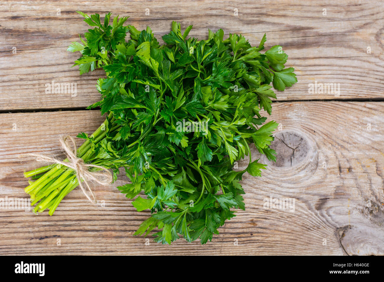Fresh green bunch of parsley on the old board Stock Photo