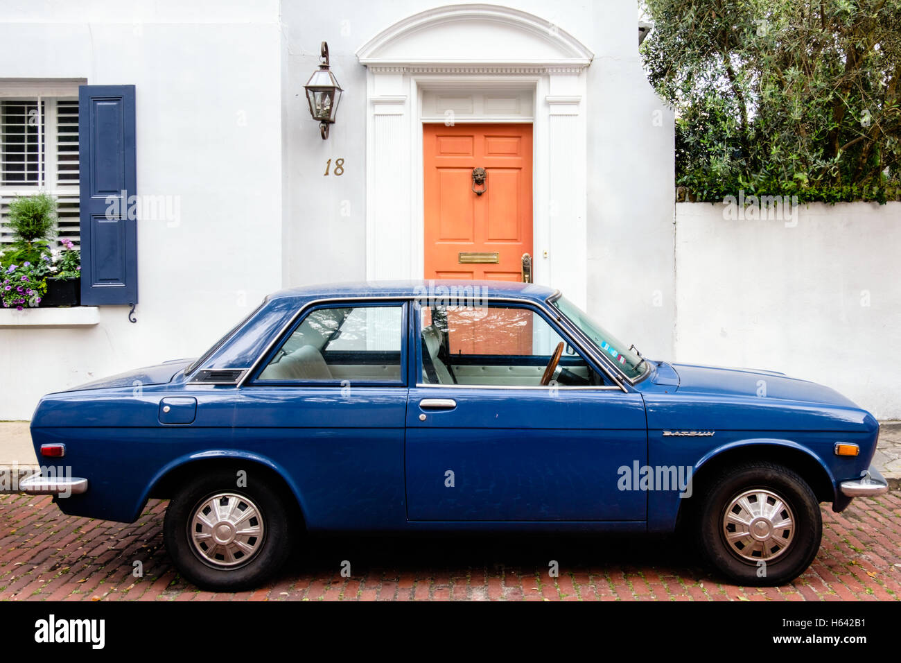Antique Datsun parked in front of an old home in the Charleston Historic District, South Carolina Stock Photo