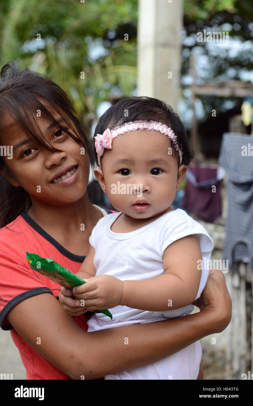 A cute Filipino girl holding a cute Filipino baby. Stock Photo
