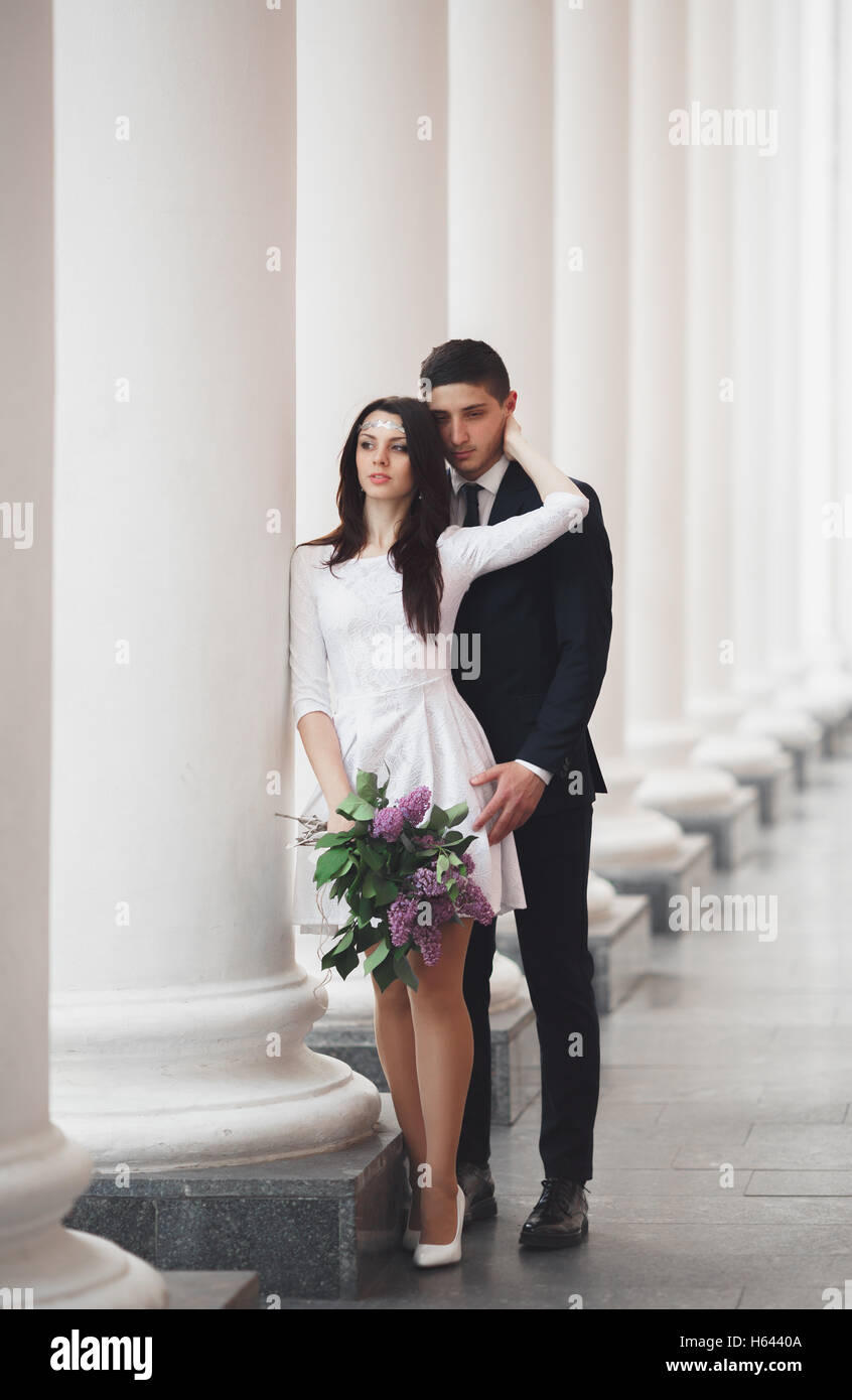Beautiful couple, bride and groom posing near big white column Stock ...
