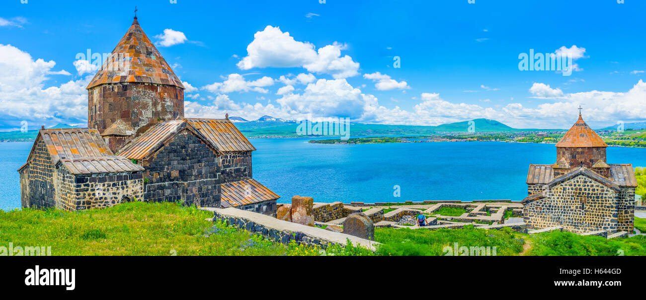 Panorama of the churches of Sevanavank Monastery, with the medieval cemetery between them and the wide Sevan Lake on background Stock Photo