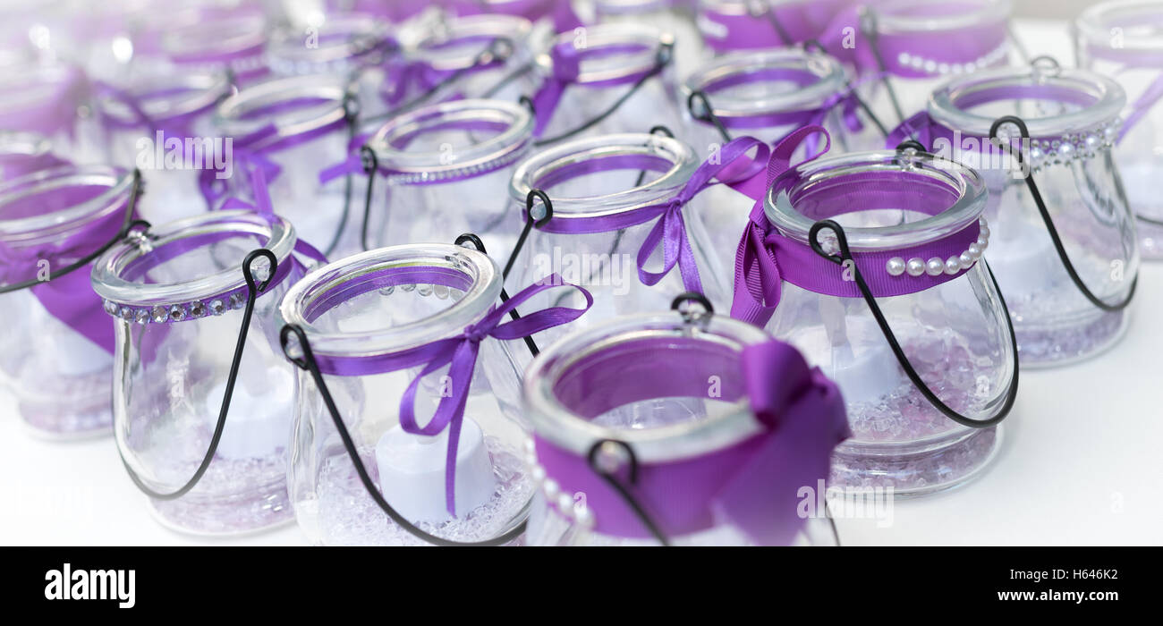 bow-tied purple ribbons on glass candle holders. Stock Photo