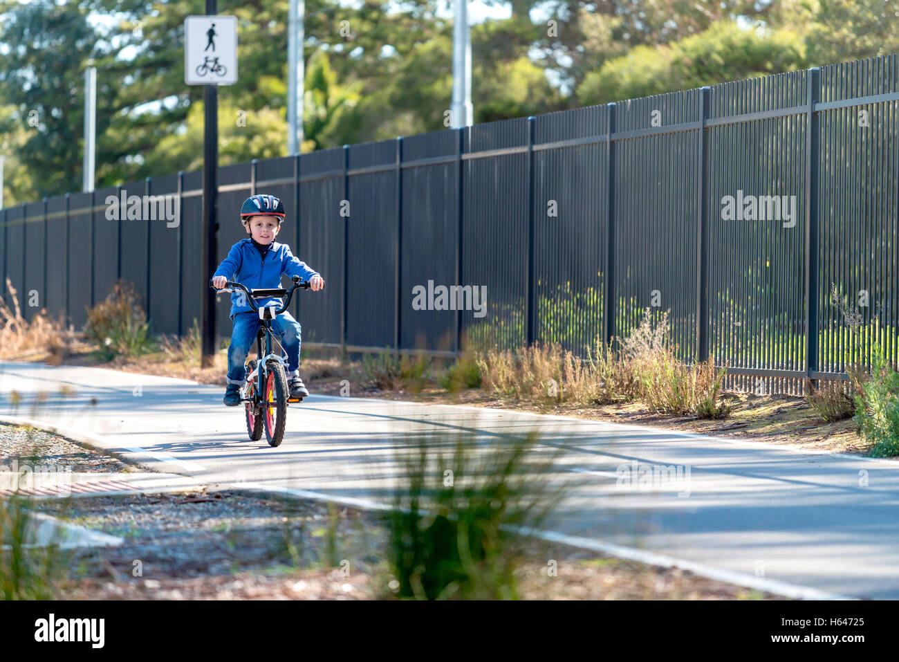 Happy aussie boy riding his bicycle on bike lane on a day, South