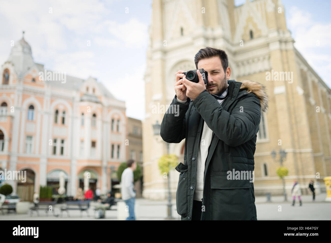 Tourist taking photos of city with camera Stock Photo