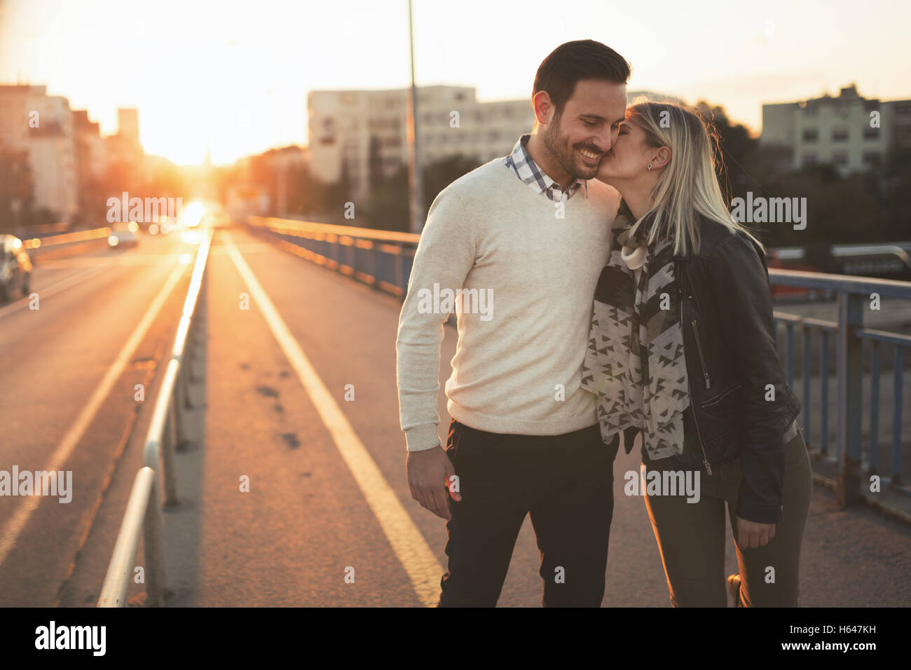 Couple kissing dating on bridge during sunset Stock Photo - Alamy