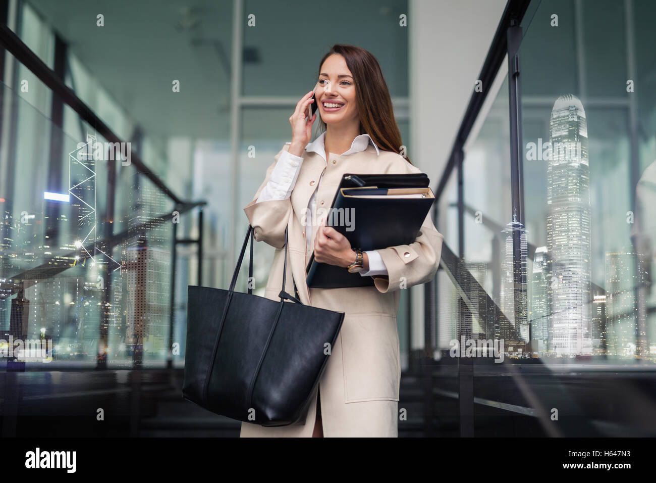 Successful businesswoman holding folders and talking on phone - double exposure Stock Photo