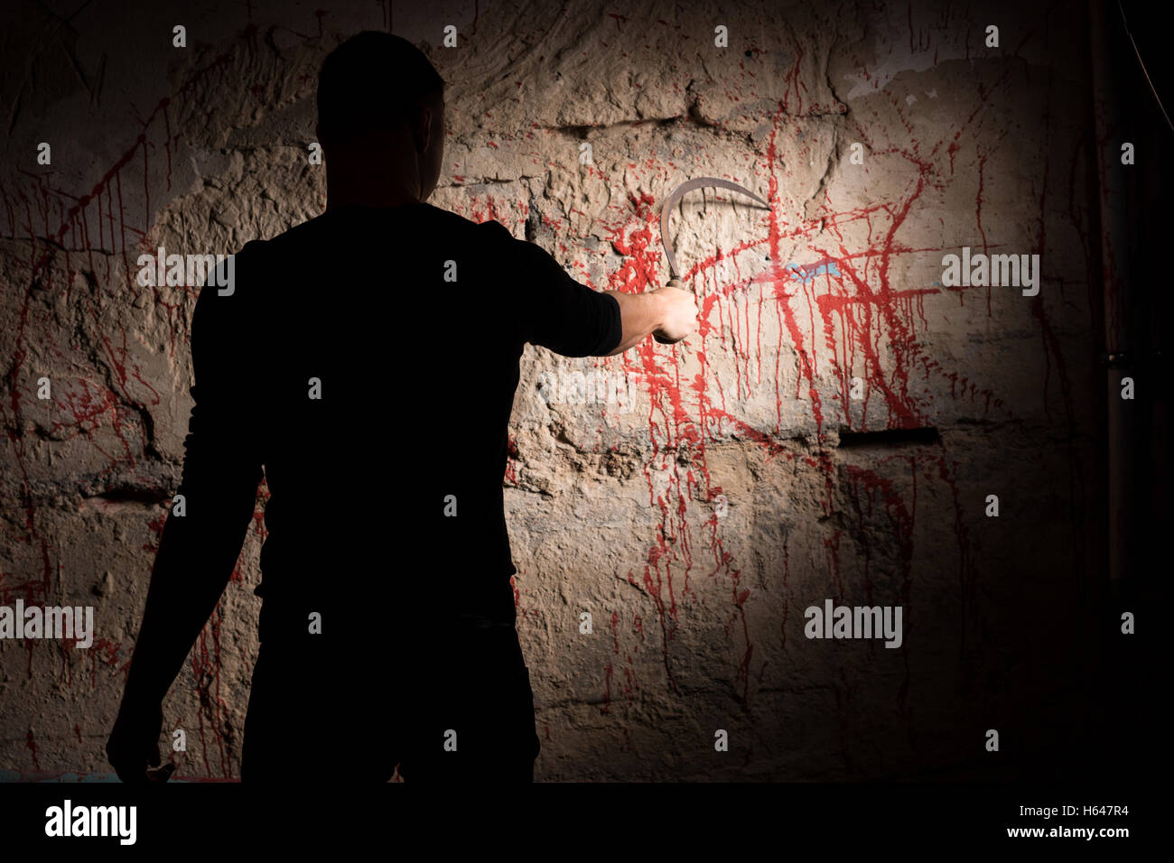 Portrait of shadowy male figure holding blade and scratching blood ...