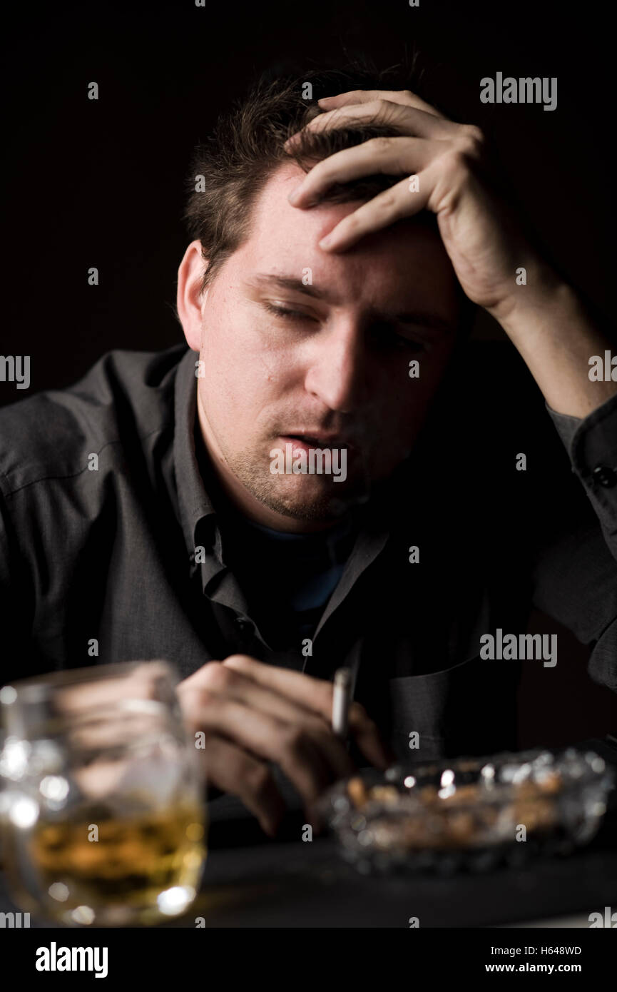 Frustrated man with alcohol and cigarette Stock Photo