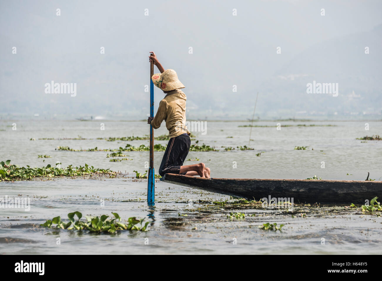 Local fishermen rowing from knees on fishing boat, Inle Lake, Shan State, Myanmar Stock Photo
