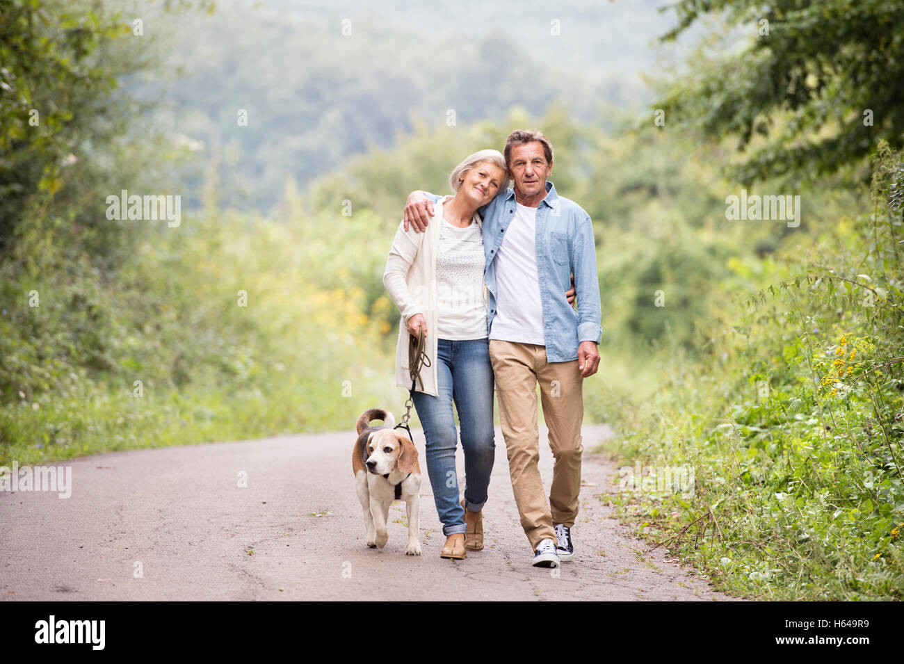 Senior couple on a walk with dog in nature Stock Photo - Alamy
