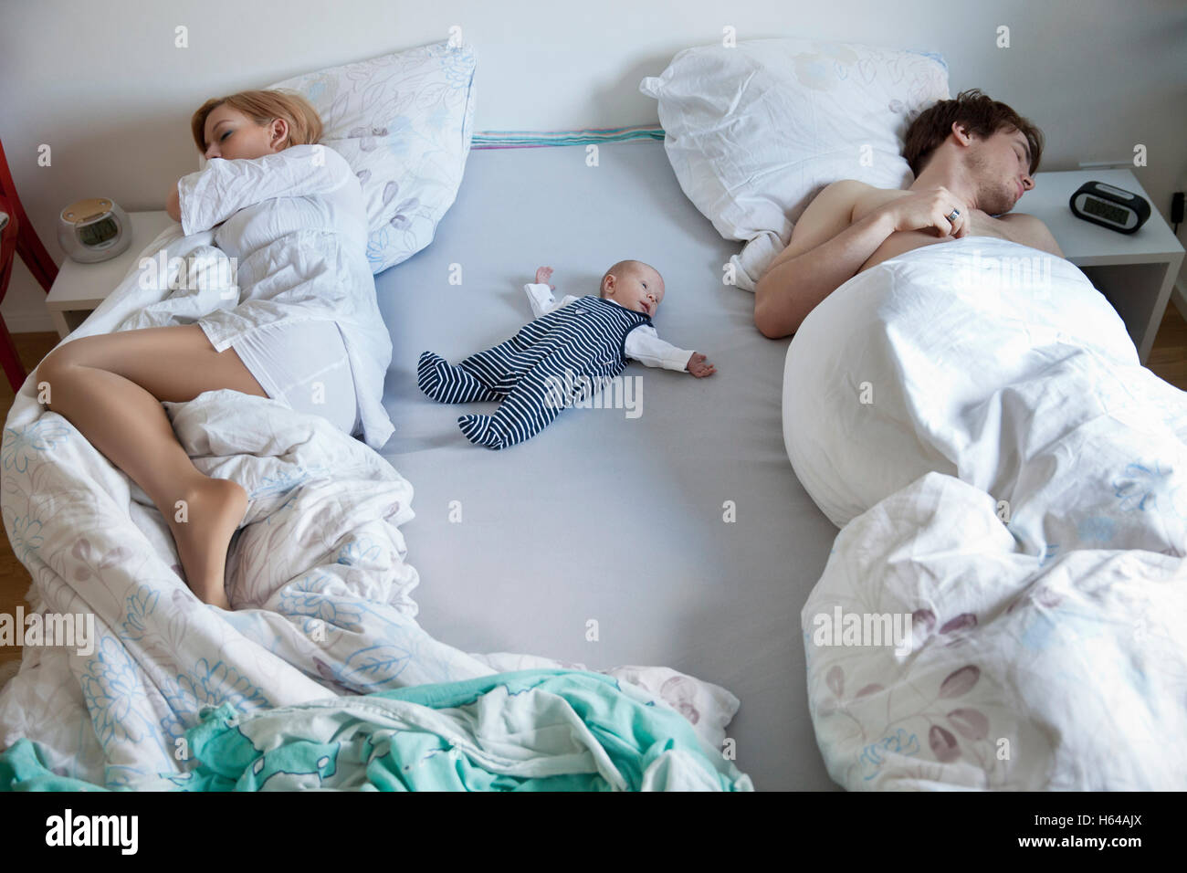 newborn baby sleeping in bed with parents