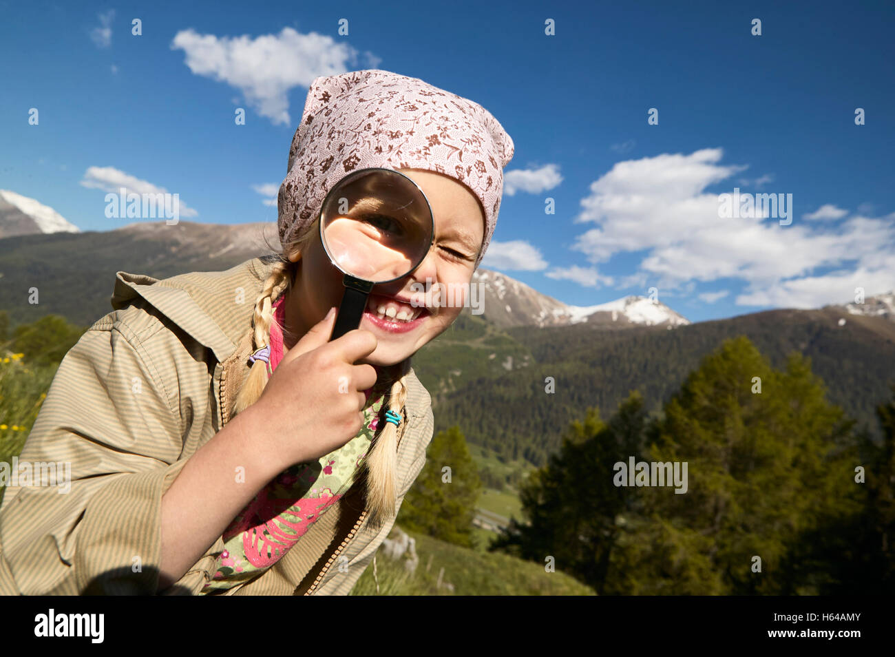 Happy girl looking through magnifying glass Stock Photo - Alamy