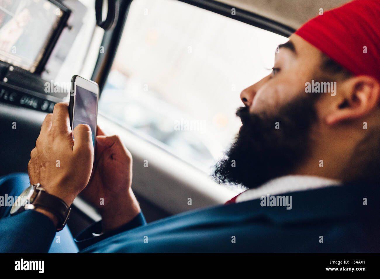 Indian businessman using smartphone in taxi Stock Photo