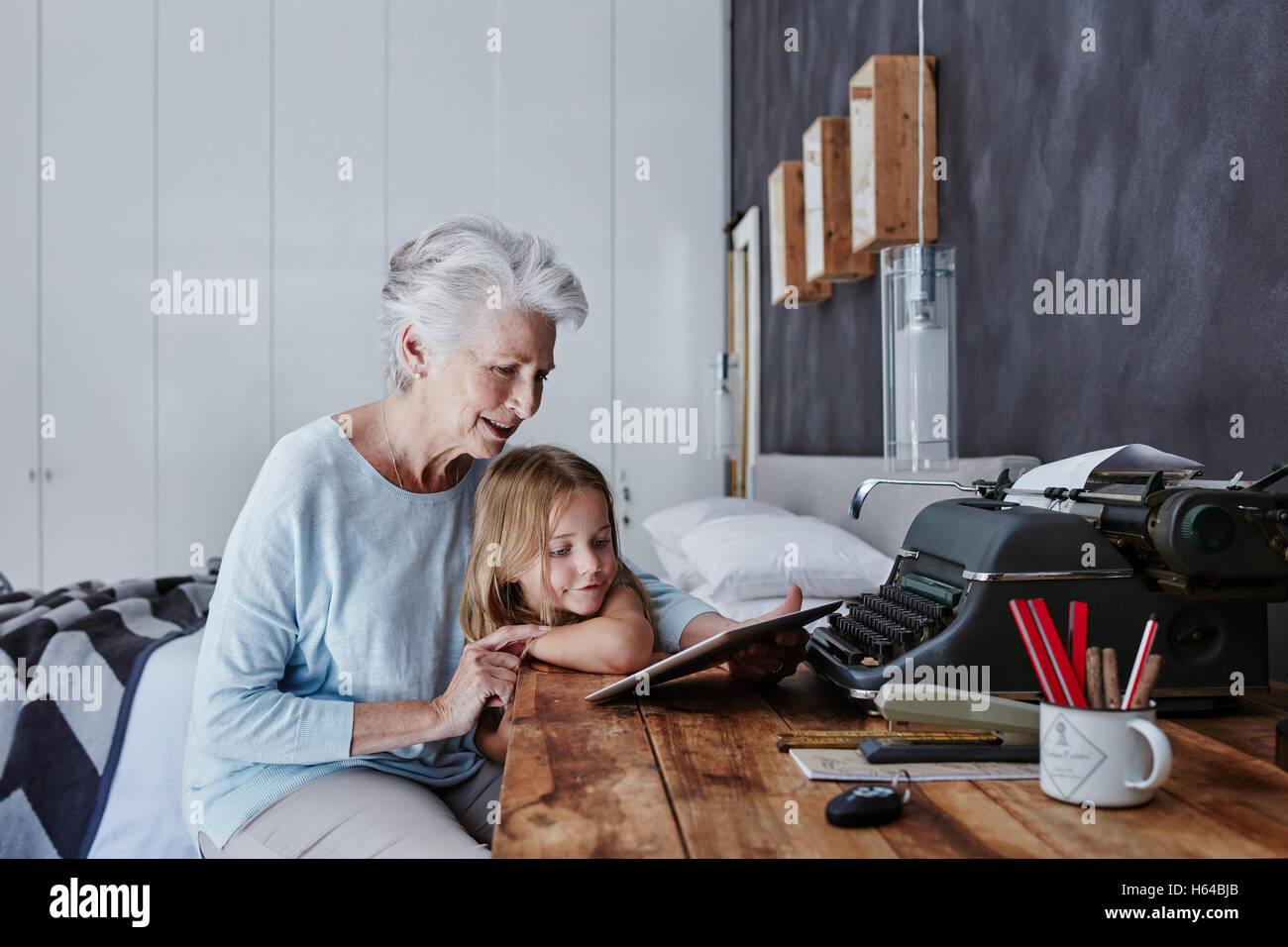 Grandmother and granddaughter looking at tablet at home Stock Photo