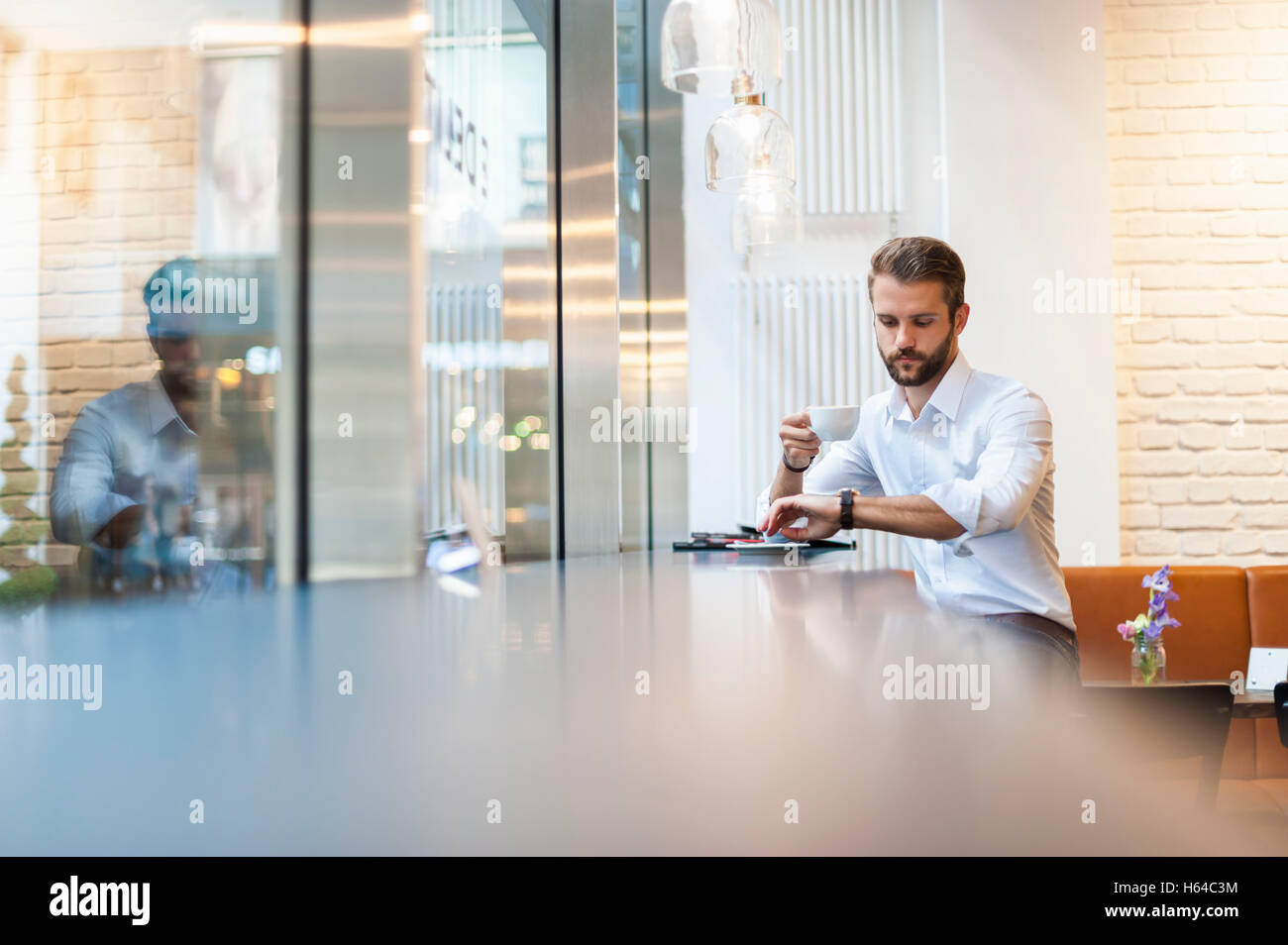 Businessman in a cafe checking the time Stock Photo