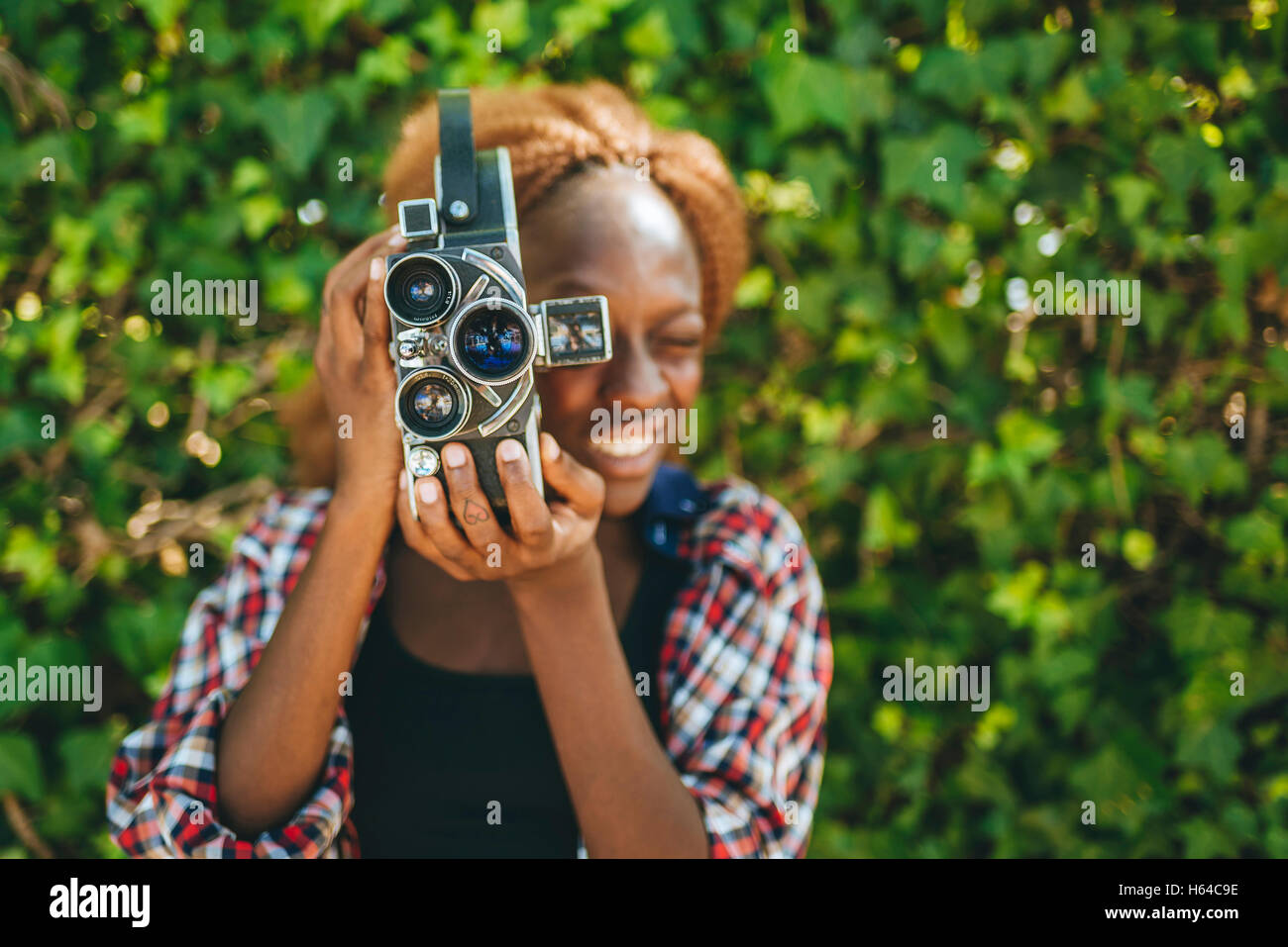 Young woman filming with an old-fashioned camera Stock Photo