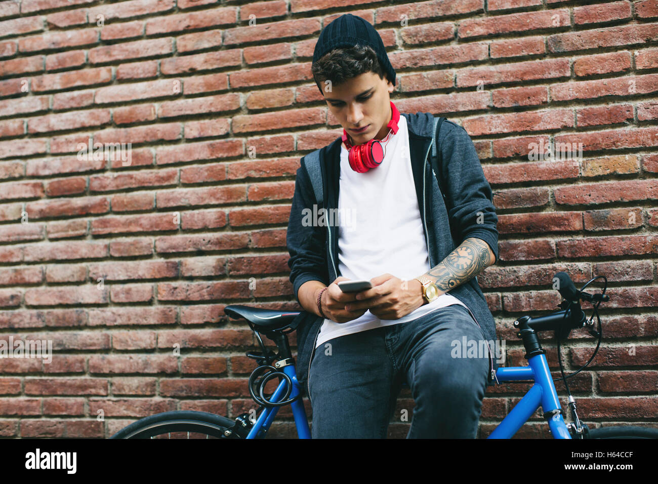 Teenager with a fixie bike, using smartphone Stock Photo