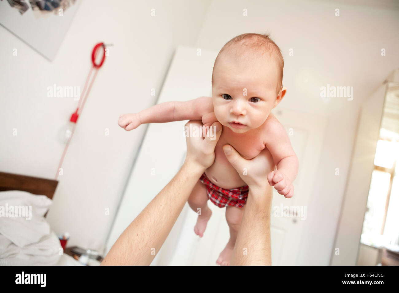 Baby being held aloft by father Stock Photo