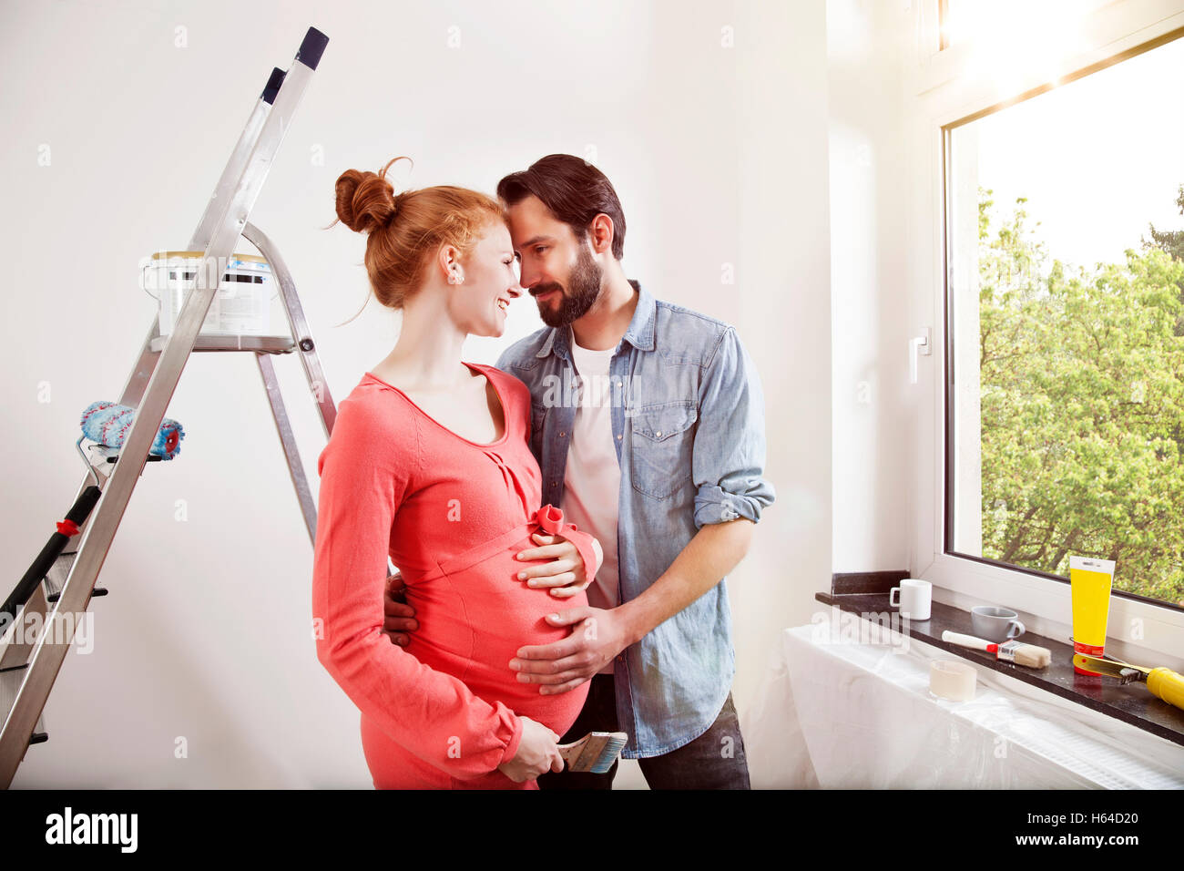 Happy man hugging pregnant woman while renovating new home Stock Photo ...