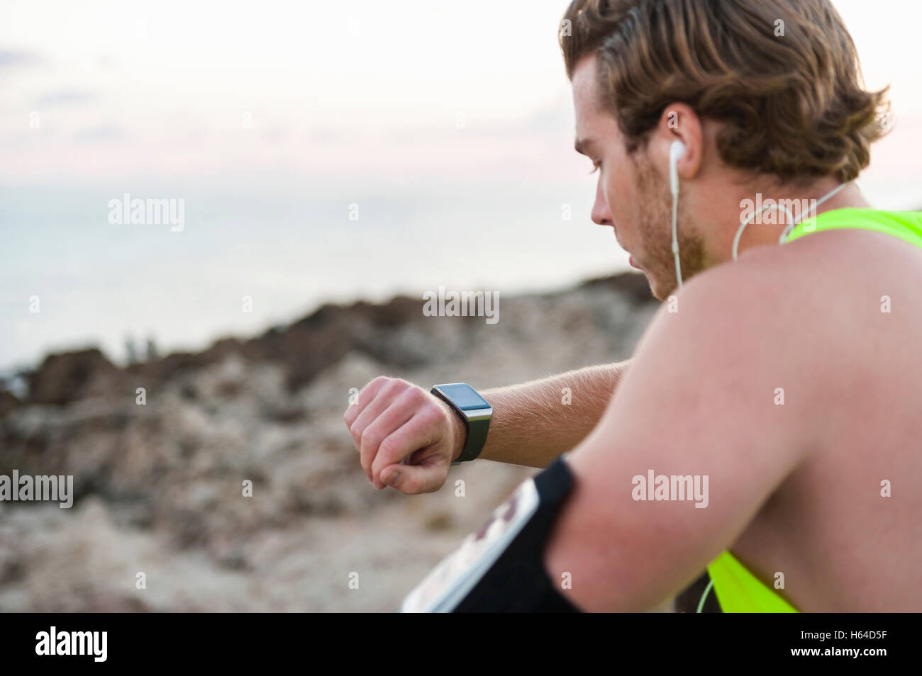 Spain, Mallorca, Jogger at the beach, looking on smartwatch Stock Photo