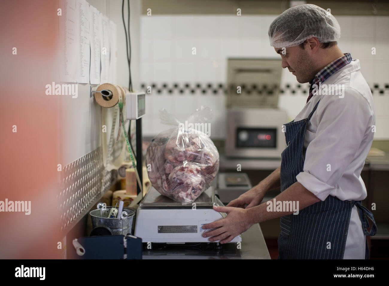 https://c8.alamy.com/comp/H64DH6/butcher-weighing-meat-on-scale-in-butchery-H64DH6.jpg