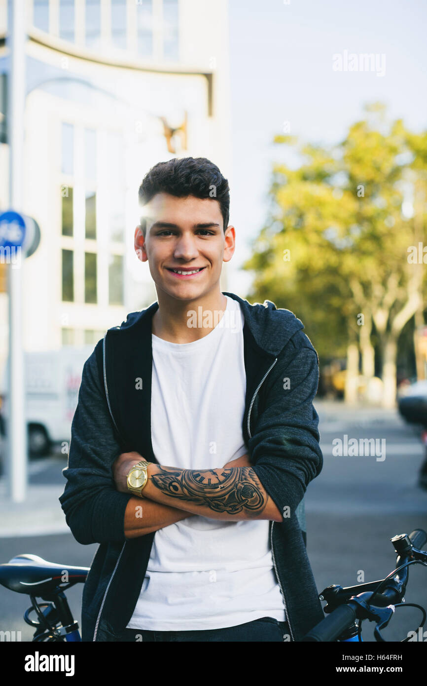 Smiling teenager with a bike in the city Stock Photo