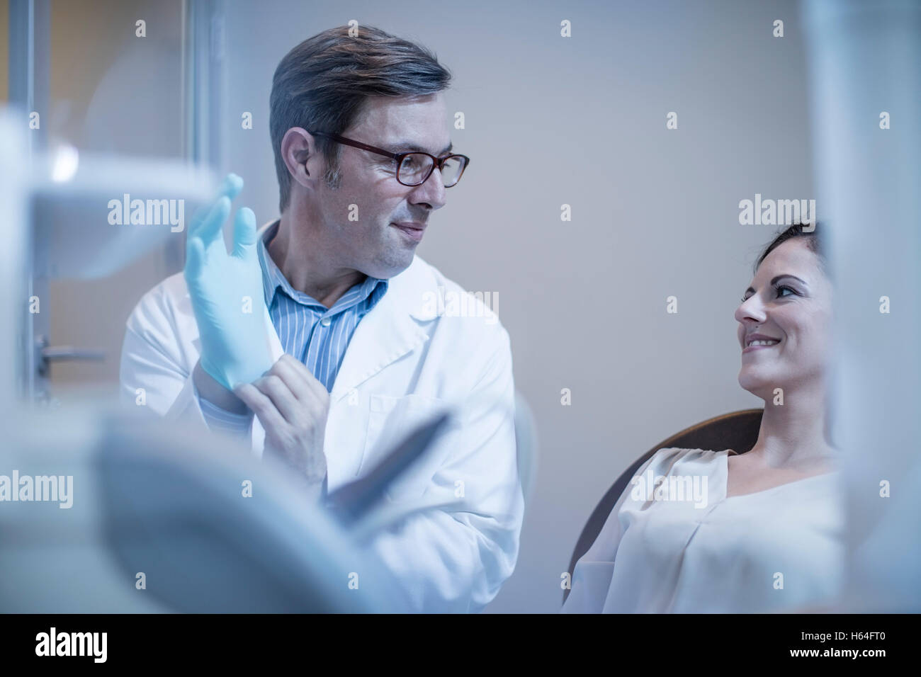 Dentist preparing treatment putting on surgical gloves Stock Photo Alamy
