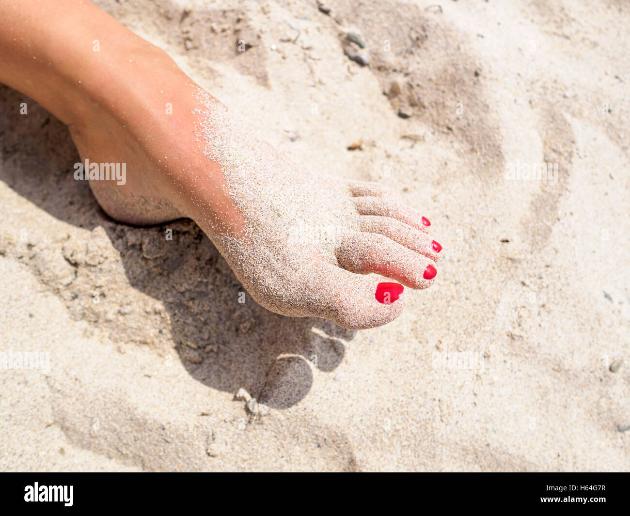 Woman's foot in the sand Stock Photo