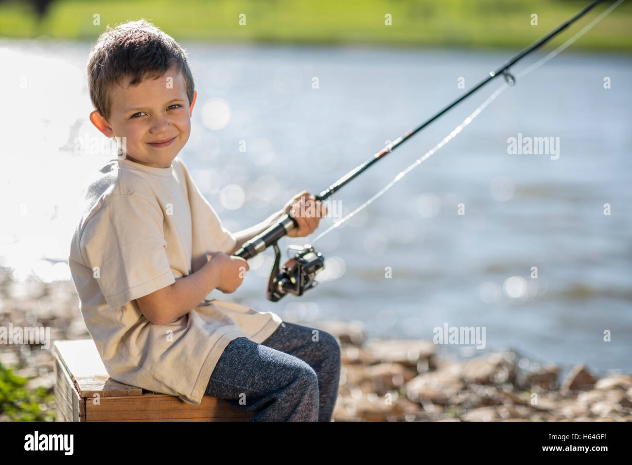 Little boy fishing in lake Stock Photo - Alamy