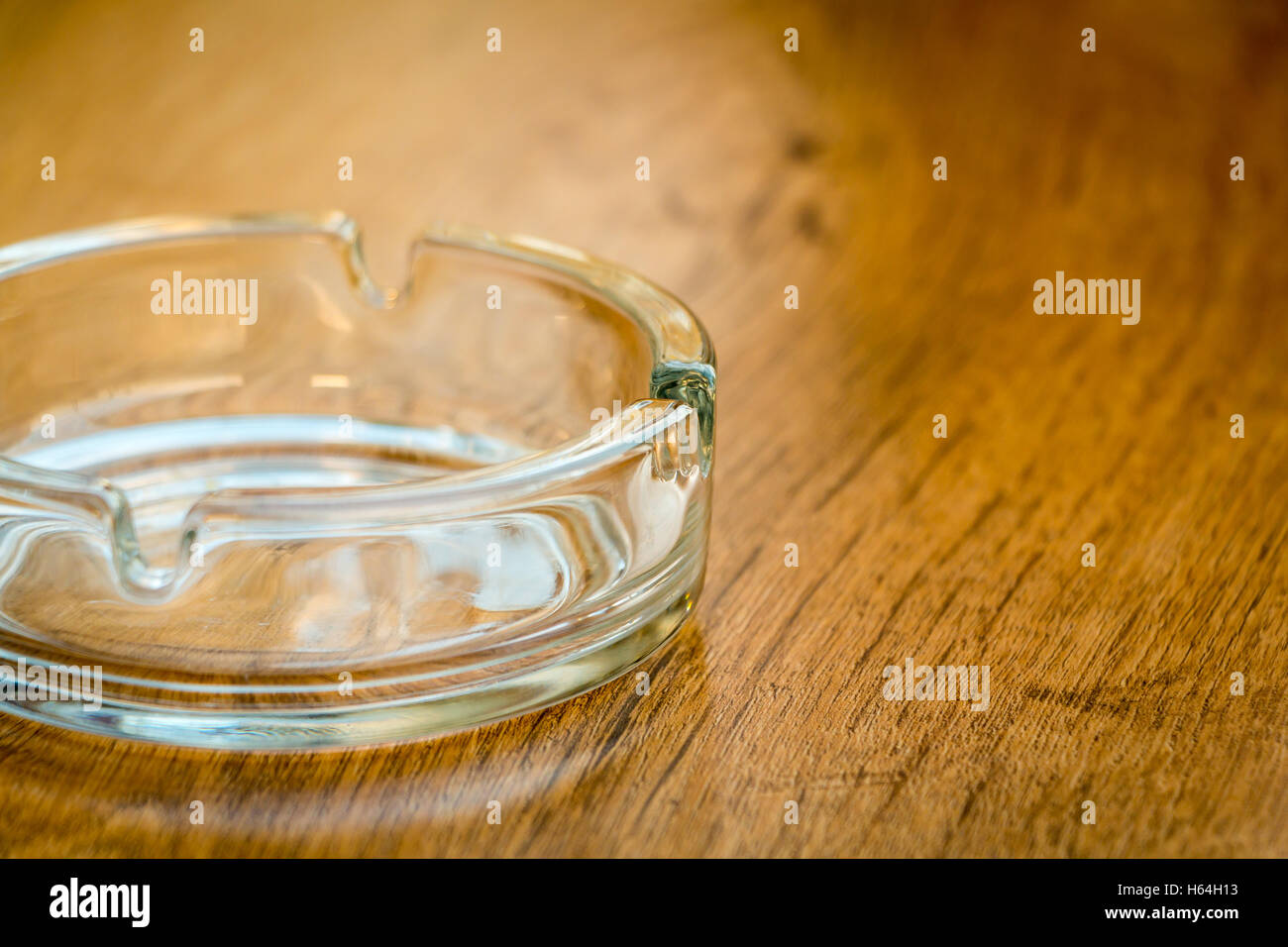 empty glass ashtray on a brown wooden table Stock Photo Alamy