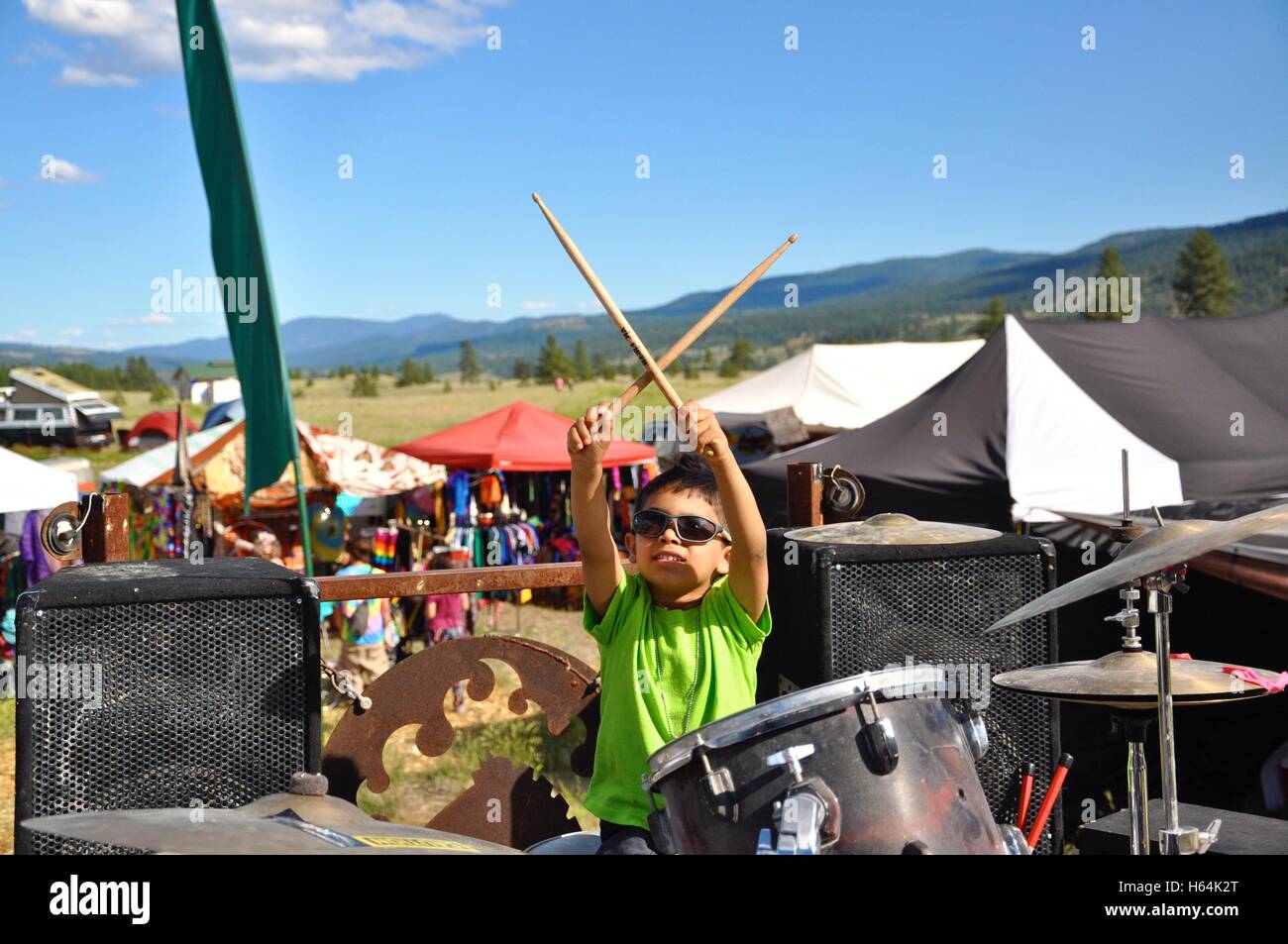 Young drummer boy holding drumsticks crisscrossed in the air. Stock Photo