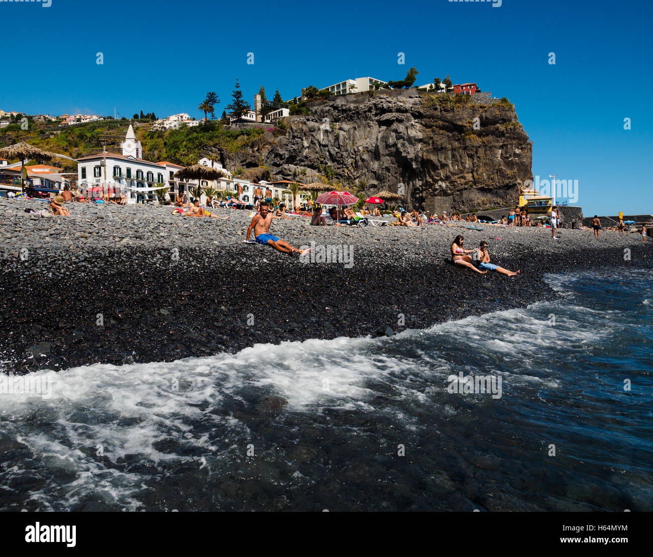 Tourists enjoy the beach of Ponta do Sol with the Enotel hotel on the Portuguese island of Madeira Stock Photo