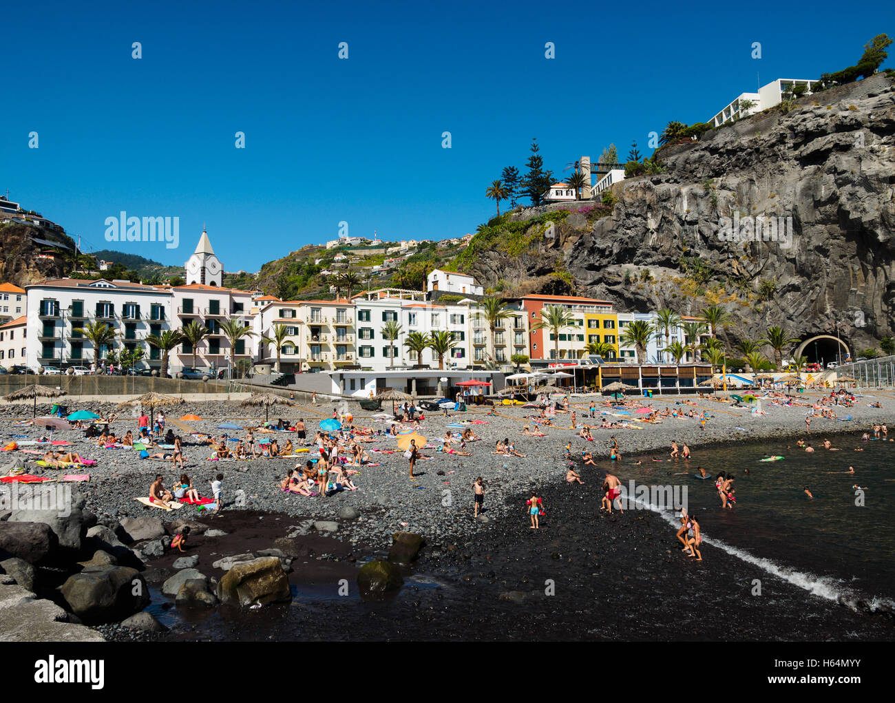 Tourists enjoy the beach of Ponta do Sol with the Enotel hotel on the Portuguese island of Madeira Stock Photo