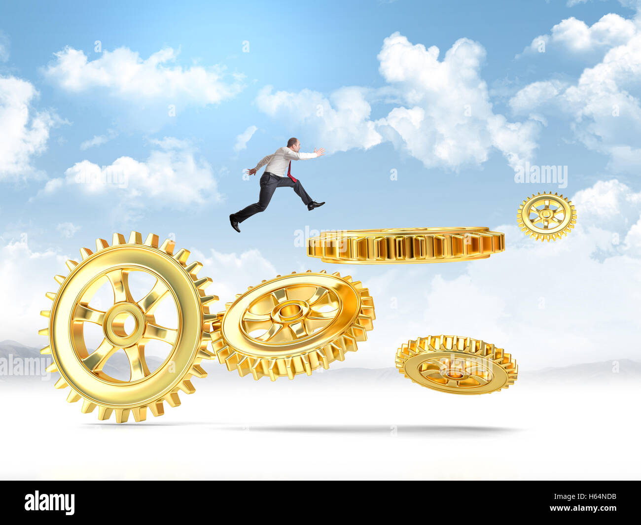 businessman jump over metal gold gear part Stock Photo