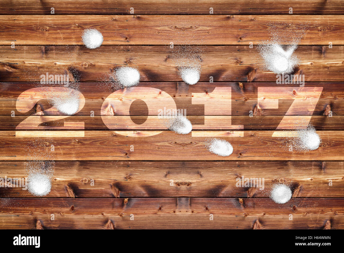 Wooden board with bleached out 2017 letters, which is bombarded with snowballs. Stock Photo