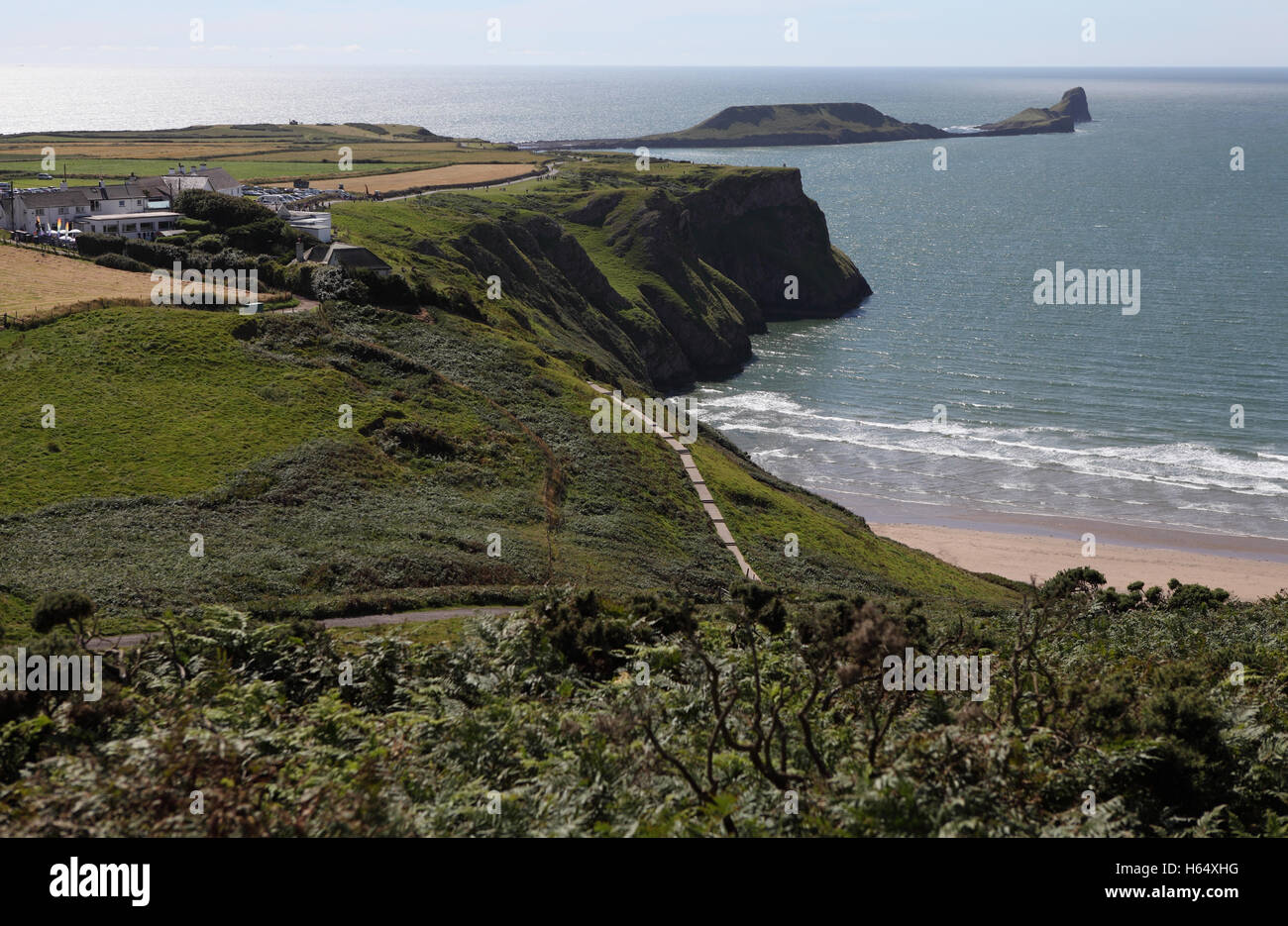 A view of Rhossili Village, the steep cliffs over Rhossili Bay, Worm's Head rock and the Celtic Sea as seen from Cefn Bryn. Stock Photo