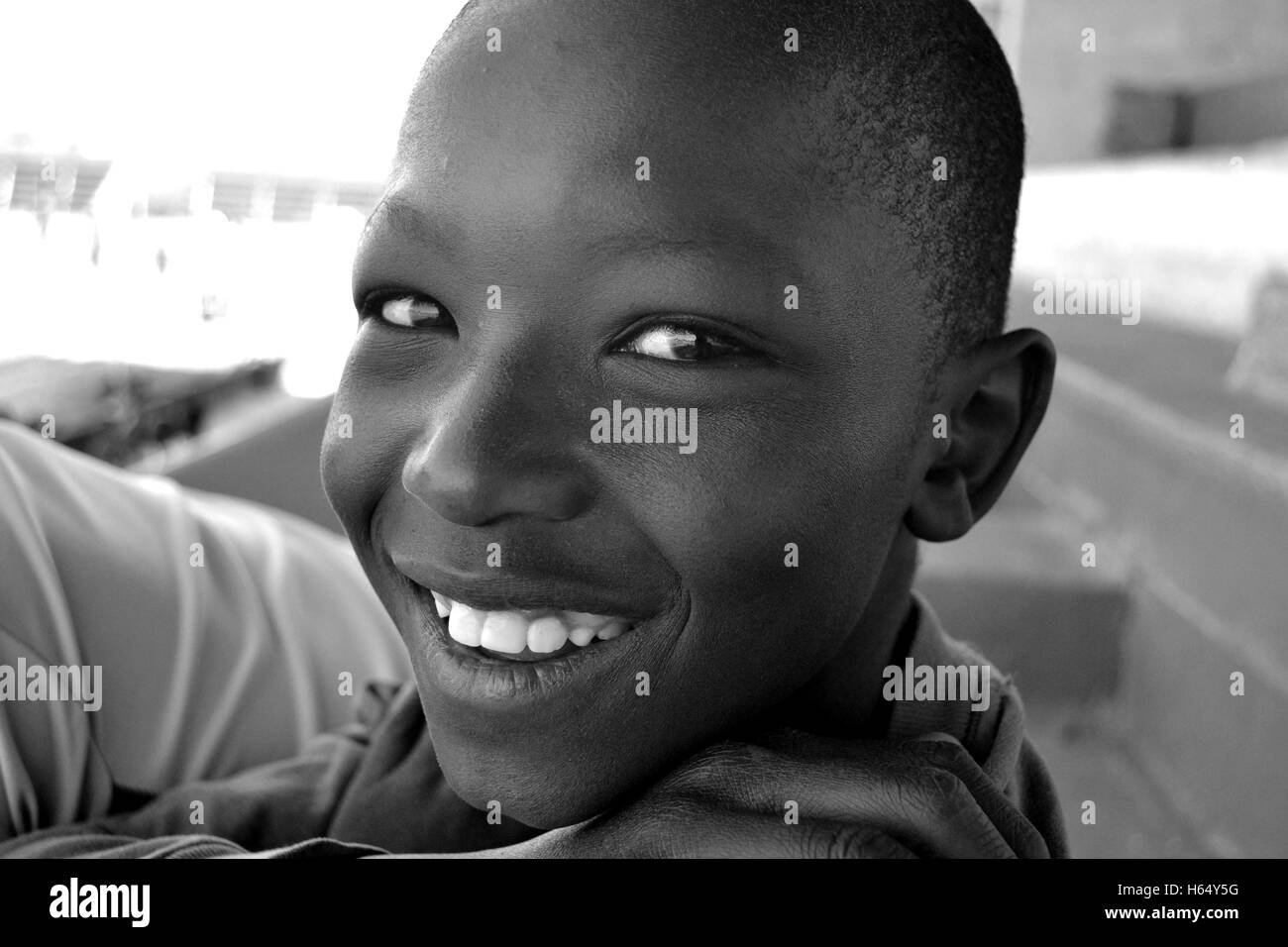 A child smiles for the camera at a football game in Woodlands, Zambia Stock Photo