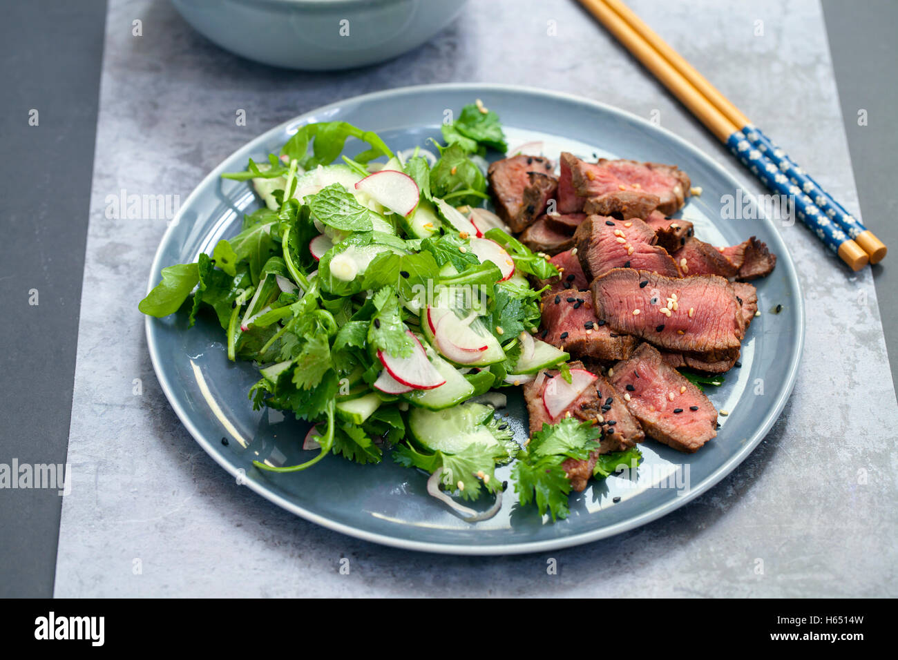 Asian beef salad with cucumber and herb salad and black and white
