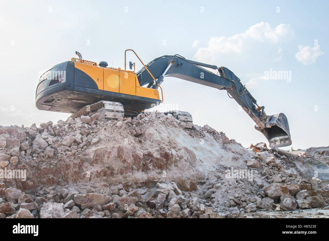 loader excavator in open sand mine over scenic blue sky Stock Photo