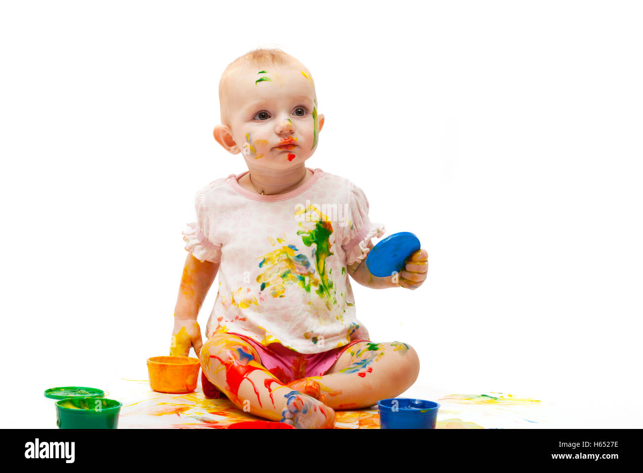 little girl soiled by multi-colored paints Stock Photo