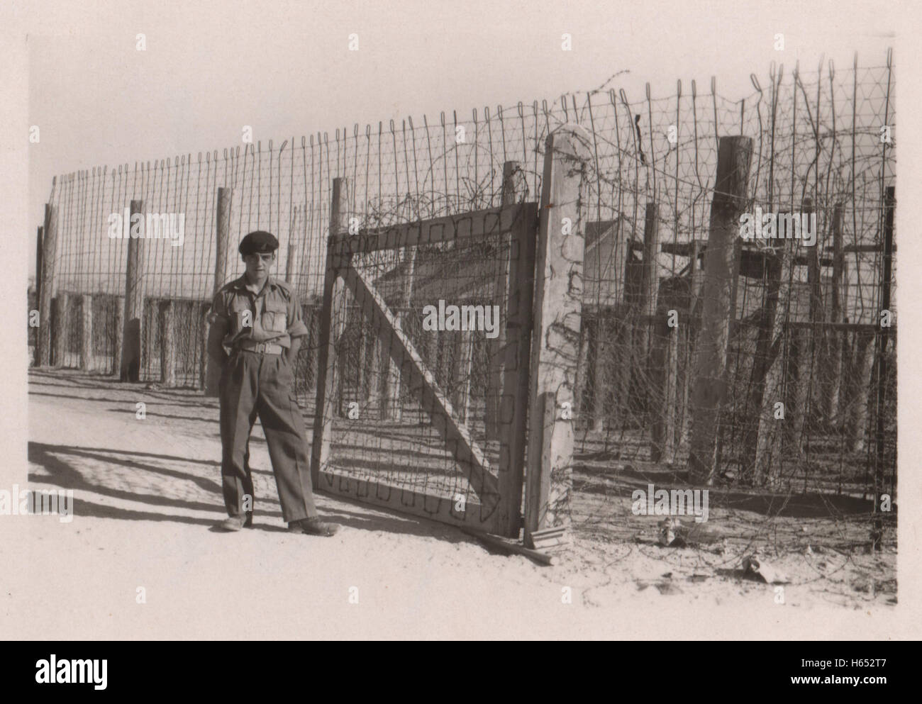 Unidentified British army soldier guarding the Arab labourers entrance at a British army base in the period prior to withdrawal of British troops from the Suez Canal zone and the Suez Crisis.  Location 10 Base Ordnance Depot Royal Army Ordnance Corps (RAOC) camp at Geneifa Ismailia area near the Suez Canal 1952. Stock Photo
