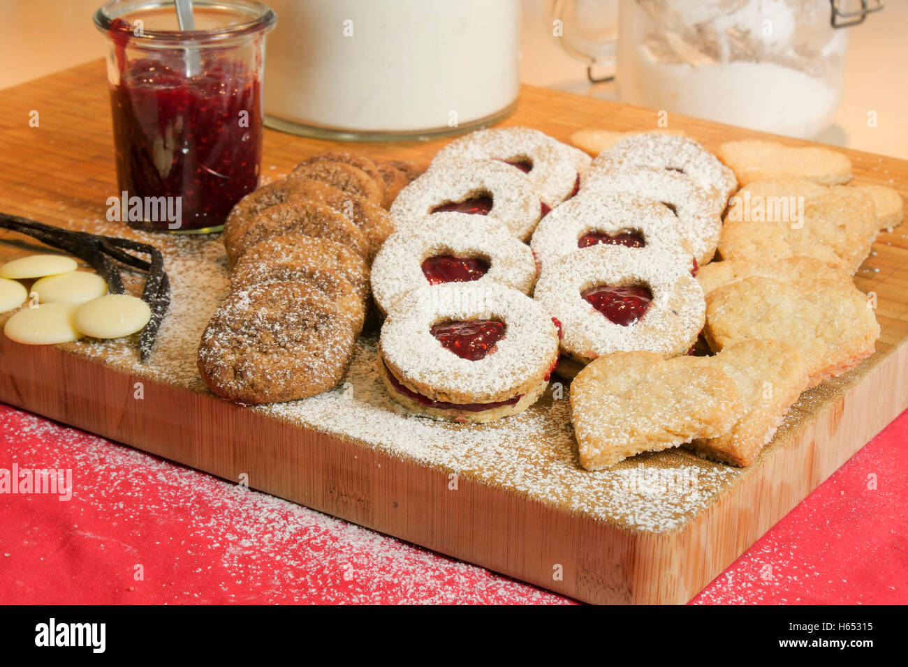 Christmas cookies on a wooden board with jam and a jar of baking powder. Stock Photo