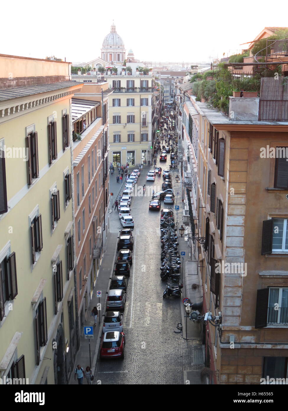 View down Via Sebastianello from Piazza Della Trinita with the dome of San Carlo El Corso in the background Stock Photo