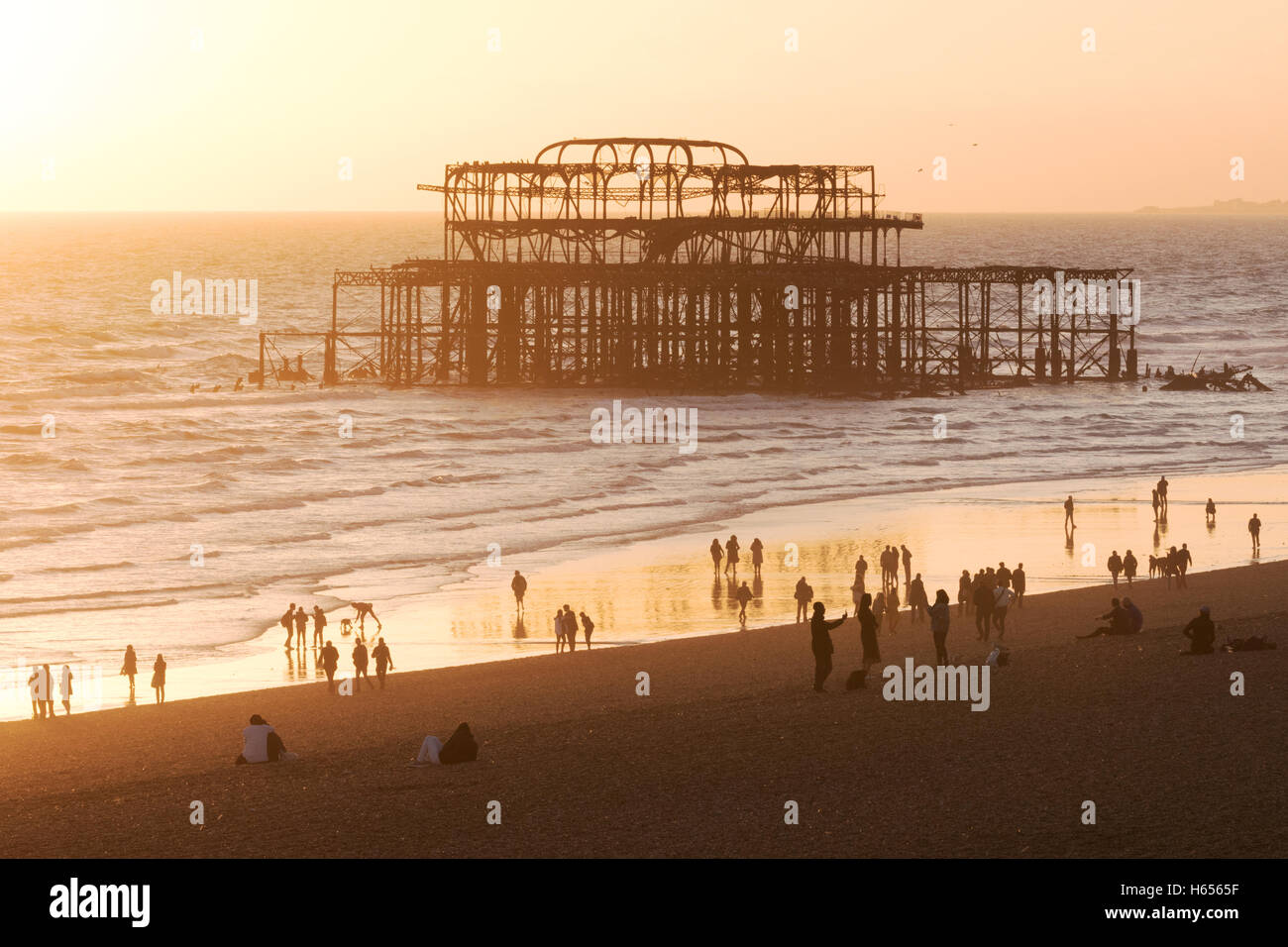 Brighton West Pier and people on the beach at sunset, Brighton, East Sussex England UK Stock Photo