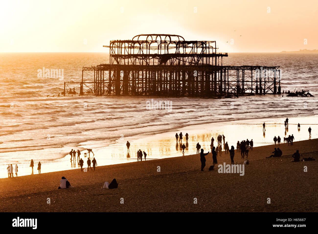 Sunset over the ruined West Pier, Brighton beach, Brighton, East Sussex England UK Stock Photo