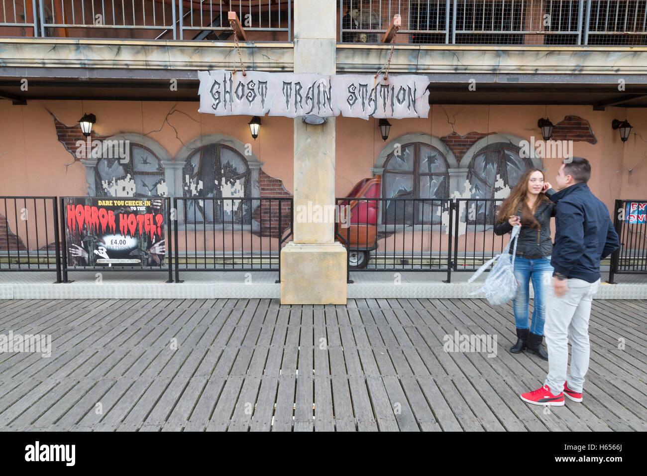A couple looking at The Ghost Train ride, Brighton Pier, Brighton, East Sussex England UK Stock Photo