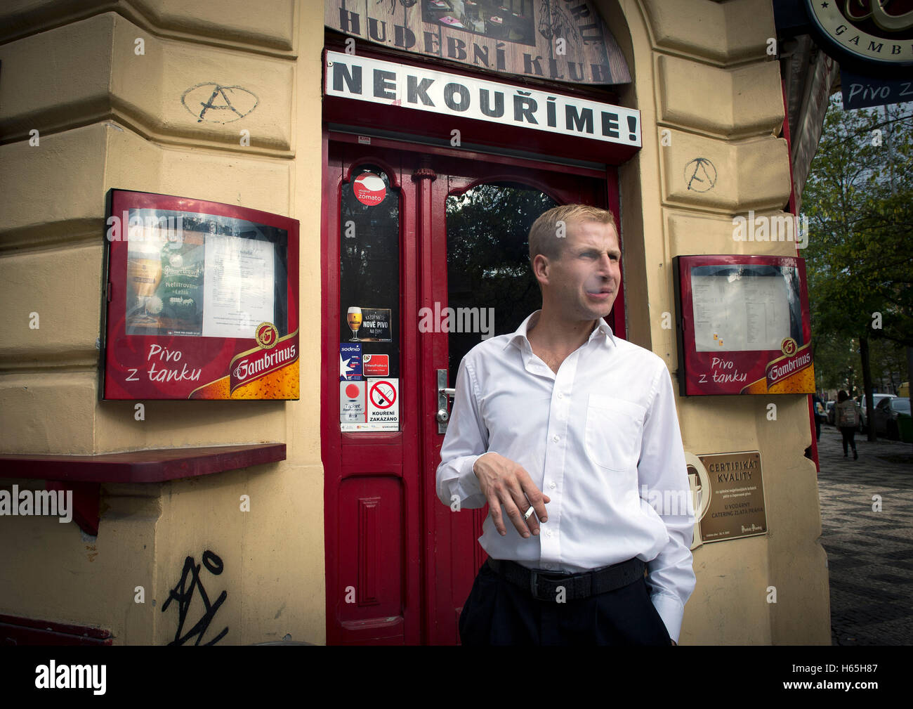 Prague, Czech Republic. 21st Oct, 2016. A waiter takes a cigarette break outside his non-smoking pub in Prague, Czech Republic, October 21, 2016. © Katerina Sulova/CTK Photo/Alamy Live News Stock Photo