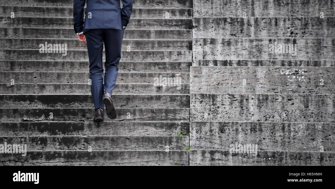 Stuttgart, Germany. 25th Oct, 2016. A man in a suit walks up the stairs with his hand in his pants' pocket in Stuttgart, Germany, 25 October 2016. Photo: MARIJAN MURAT/dpa/Alamy Live News Stock Photo