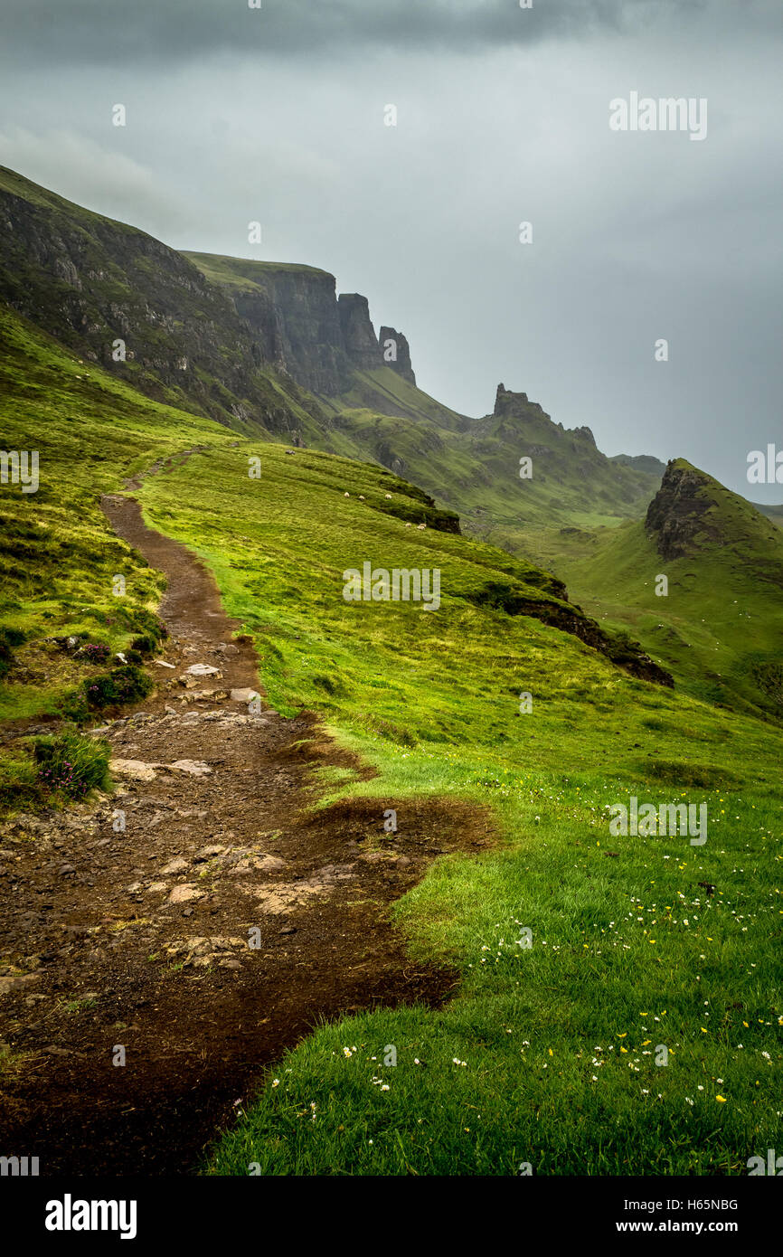 Hiking Path On The Quiraing, Isle of Skye, Scotland With Mountain Peaks In The Distance And Lush Grass Stock Photo