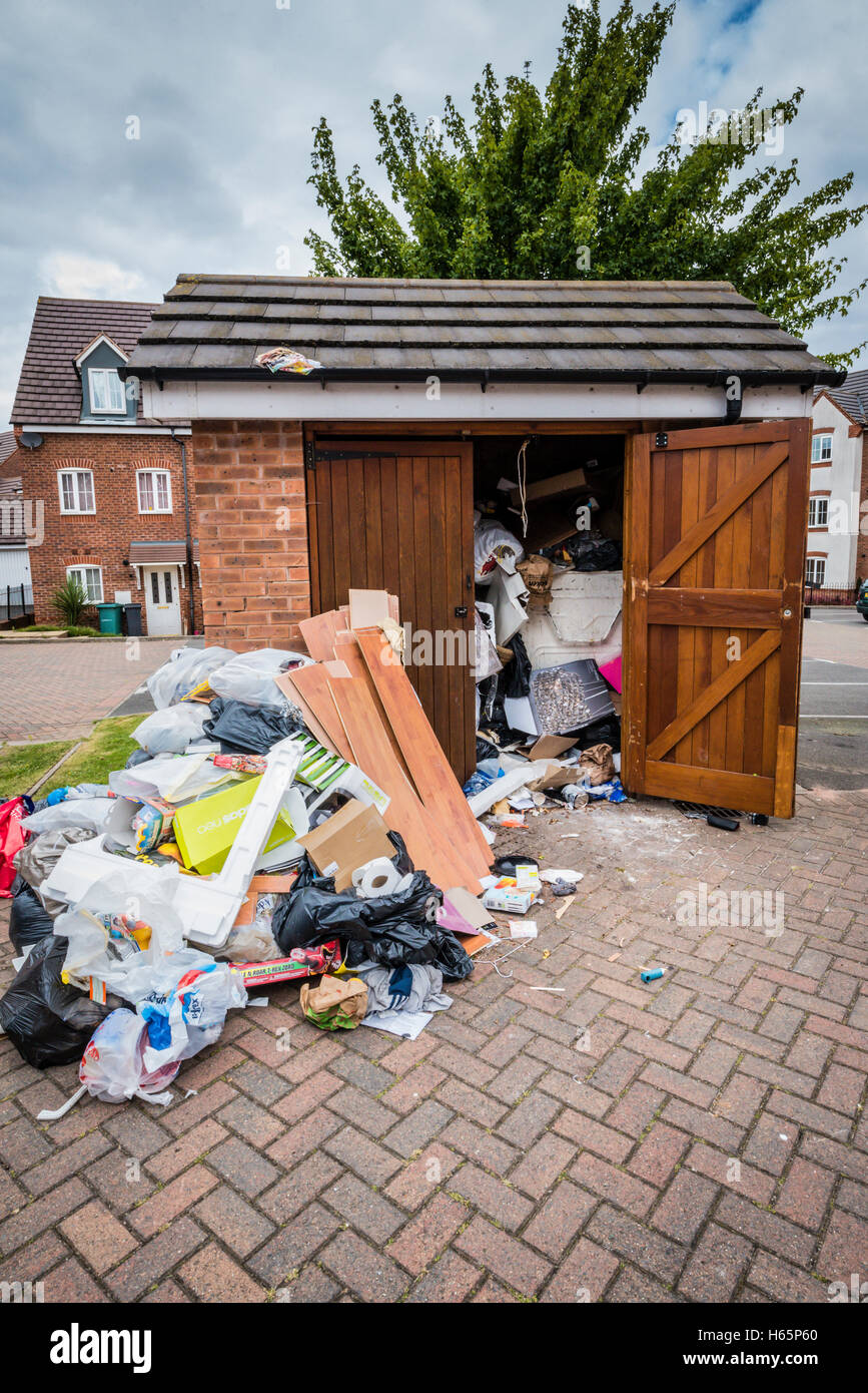 Out-building, storage with rubbish and household waste dumped outside private flats Stock Photo